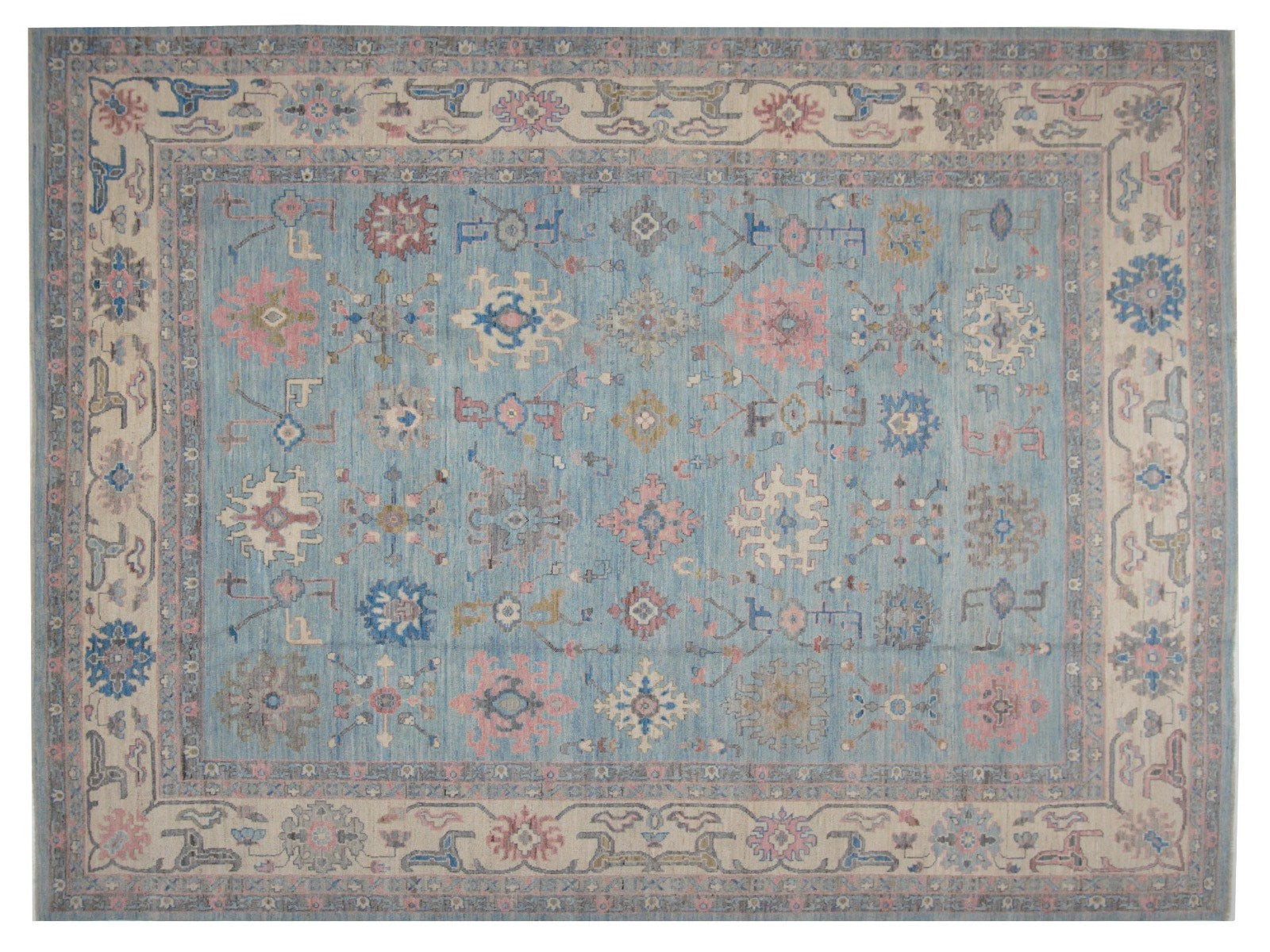 Vibrant Turkish Oushak rug featuring a light blue base adorned with colorful motifs in pink, dark blue, orange, beige, and gray.
